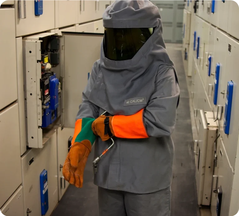 A man in a fireproof safety suit gears up to perform an electrical check.