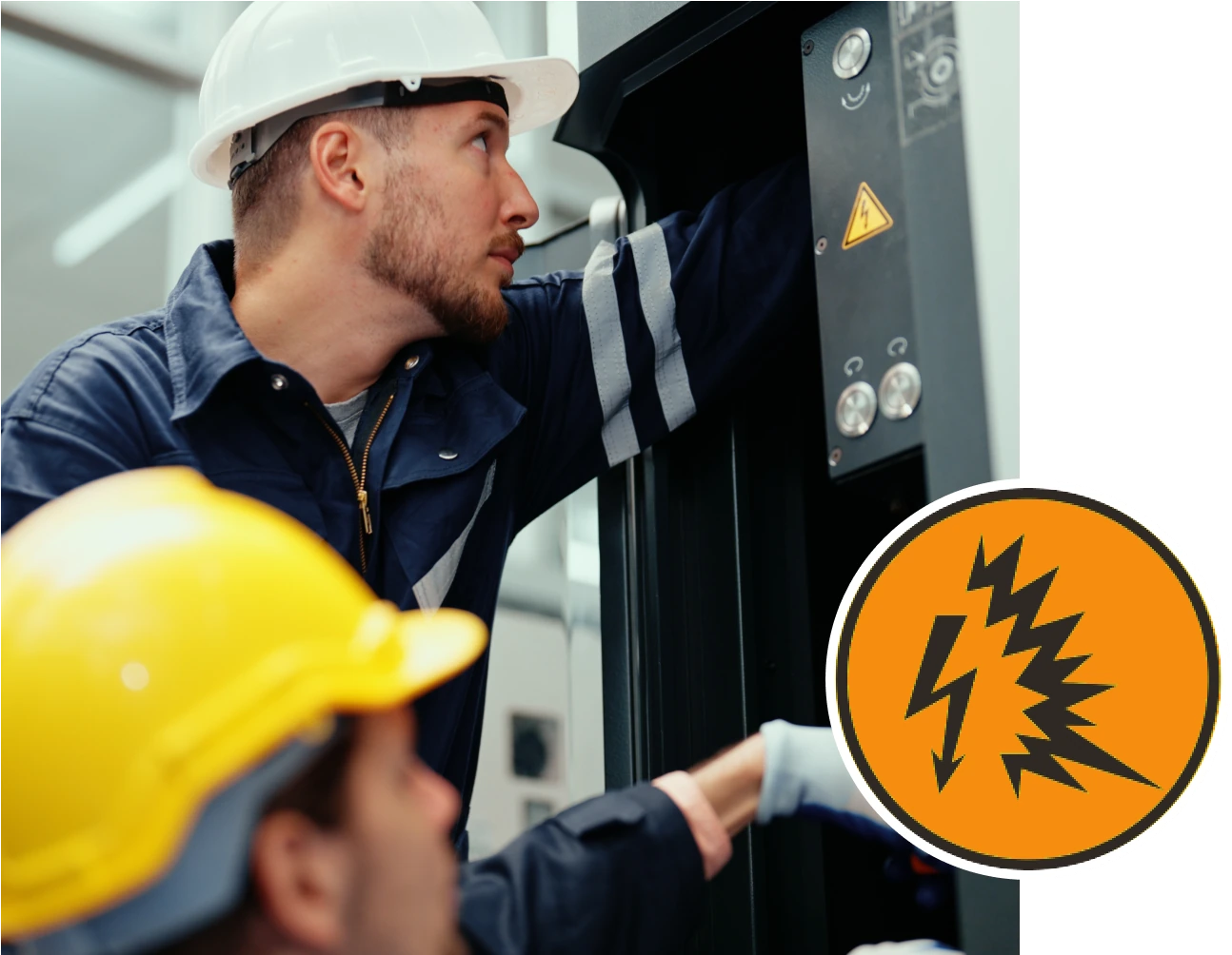 Two men bend down in front of an electrical box to perform work on it.